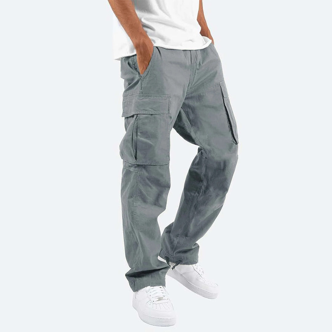 Bruine cargobroek voor heren, zijaanzicht. Casual streetwear stijl, met grote zakken en elastische enkels. Perfect voor dagelijks gebruik.
