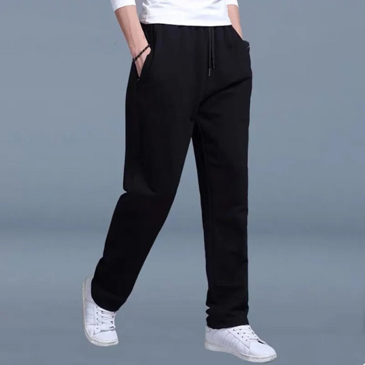 Vier heren joggingbroeken in grijs, zwart en blauw, gedragen met witte sneakers. Comfortabele sportkleding voor mannen, ideaal voor casual en sportief gebruik.